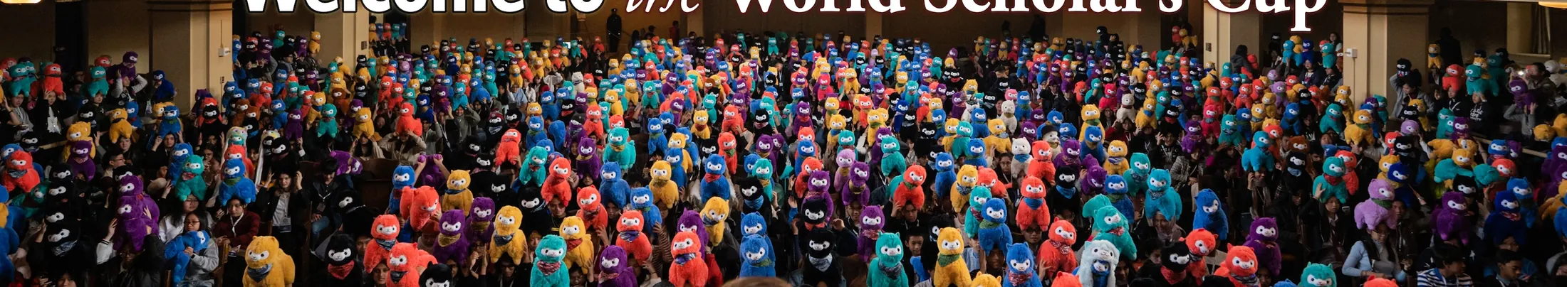 A theater full of scholars holding up colorful toy alpacas
