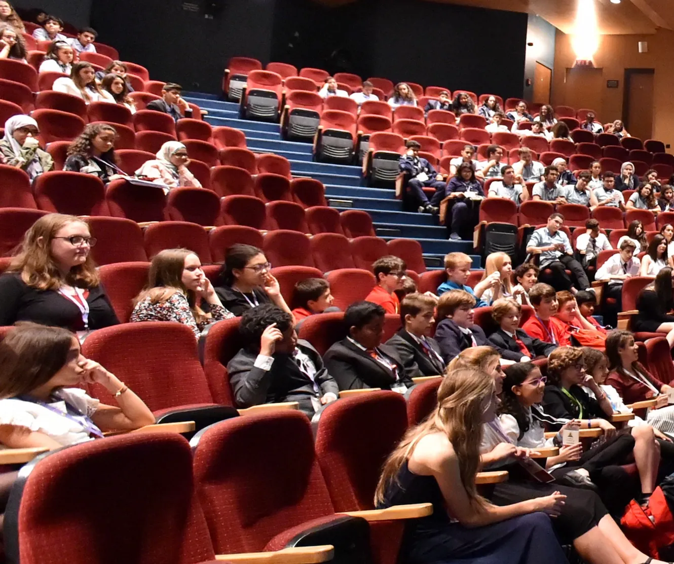 Scholars from many countries fill a theatre at a regional round